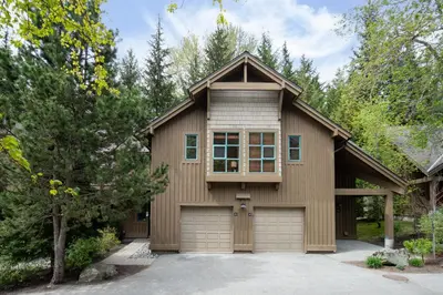 a house with a garage in a driveway at 3BR in The Woods, Private Hot Tub, Wood Burning Fireplace, King Ensuite, Private Garage in Whistler