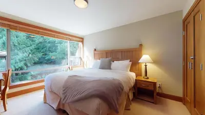 a bedroom with a large bed and a large window at 3BR in Montbello, Cozy Townhouse, Private Hot Tub, Near Village, Fireplace in Whistler