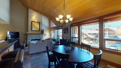 a dining room with a table and a living room at 3BR in Montbello, Cozy Townhouse, Private Hot Tub, Near Village, Fireplace in Whistler