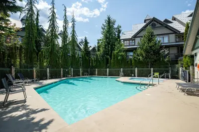 a large swimming pool with chairs and a fence at 1BR in Northstar, Village Location, Shared Pool and Hot Tub, Ski Storage, Free Parking in Whistler