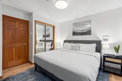 a bedroom with a large bed and a mirror at 1BR in Northstar, Village Location, Shared Pool and Hot Tub, Ski Storage, Free Parking in Whistler