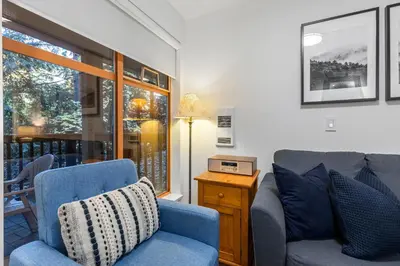 a living room with a blue couch and a table at 1BR in Northstar, Village Location, Shared Pool and Hot Tub, Ski Storage, Free Parking in Whistler