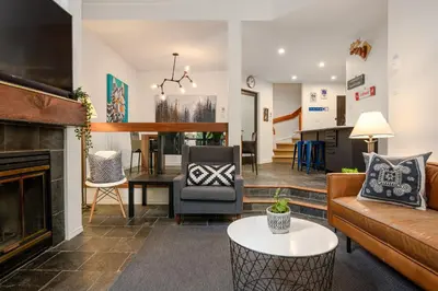 a living room with a couch and a table at 2BR plus Den in The Gables, Dog Friendly, Near Both Mountains, Wood Burning Fireplace, Free Parking in Whistler
