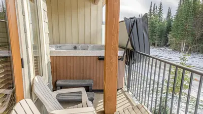 a porch with two chairs and a tub on a balcony at Echo Landing #05 by Bear Country in Sun Peaks