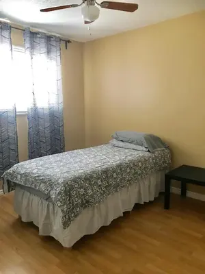a bedroom with a bed and a ceiling fan at Private Rooms in a 3 Bedroom Guest House Close to Kingsway NAIT 1 Person per Room No Couples For Men Only in Edmonton