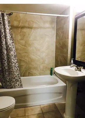 a bathroom with a tub and a sink and a toilet at Private Rooms in a 3 Bedroom Guest House Close to Kingsway NAIT 1 Person per Room No Couples For Men Only in Edmonton