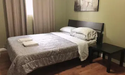 a bedroom with a bed and a table with towels on it at Private Rooms in a 3 Bedroom Guest House Close to Kingsway NAIT 1 Person per Room No Couples For Men Only in Edmonton