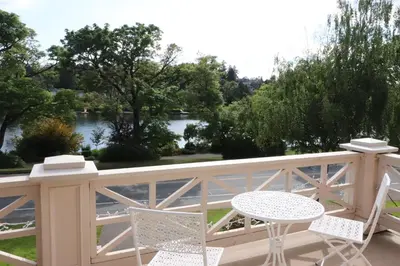 a balcony with a table and chairs and a view of a river at Lipton Place by Elegant Waterfront in Victoria