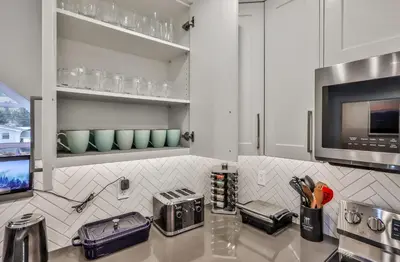 a kitchen with white cabinets and a counter top at The Parq by Samsara Resort Top View Downtown 4BR & 3BTH in Canmore