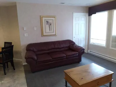 a living room with a brown leather couch and a coffee table at Fairmont Mountain View Villas in Fairmont Hot Springs