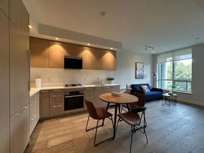a kitchen and living room with a table and chairs at UBC Pacific Spirit Modern Style Home in Vancouver
