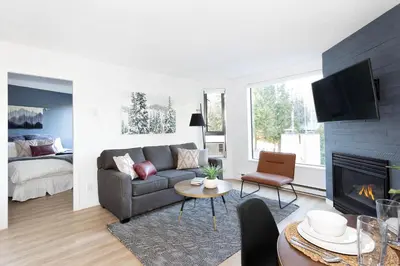 a living room with a couch and a fireplace at Contemporary & Spacious Slopeside 1BR Getaway in Whistler
