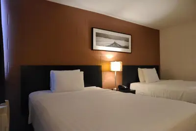 a hotel room with two beds and a picture on the wall at Roadking Inns Motel in Calgary