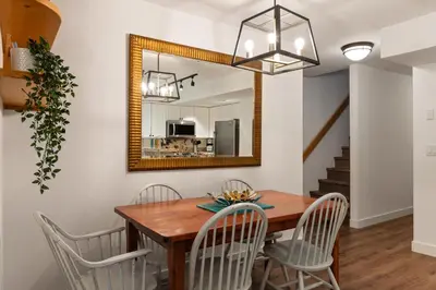 a dining room with a table and chairs and a mirror at 3BR in Valhalla, Village Location, Communal Hot Tub, Gas Fireplace, Parking in Whistler