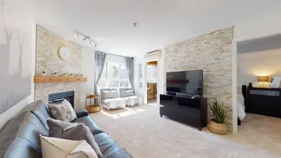 a living room with a couch and a fireplace at 1BR and Den in Marketplace Lodge, Gas Fireplace, Village Location, Complex Hot Tub in Whistler