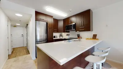 a kitchen with a white counter top and wooden cabinets at 1BR and Den in Marketplace Lodge, Gas Fireplace, Village Location, Complex Hot Tub in Whistler