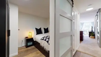 a bedroom with a bed and a sliding glass door at 1BR and Den in Marketplace Lodge, Gas Fireplace, Village Location, Complex Hot Tub in Whistler