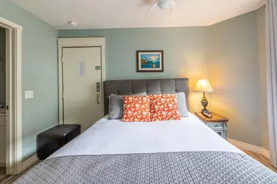 a bedroom with a large bed and a lamp at Windtower Lodge - Canmore in Canmore