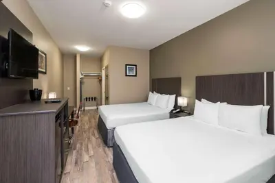 a hotel room with two beds and a flat screen tv at Econo Lodge in Prince George