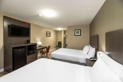 a hotel room with two beds and a flat screen tv at Econo Lodge in Prince George
