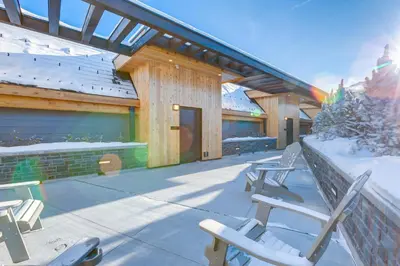 a building with snow on the ground and benches at Peaks Hotel and Suites in Banff