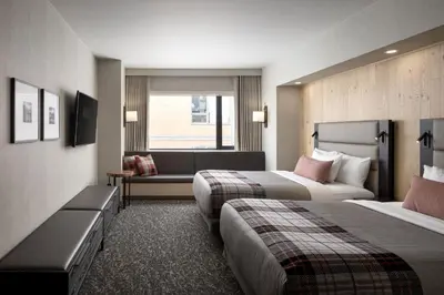 a hotel room with two beds and a couch at Peaks Hotel and Suites in Banff