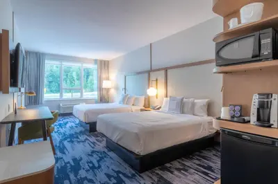 a hotel room with two beds and a flat screen tv at Fairfield by Marriott Inn & Suites Revelstoke in Revelstoke
