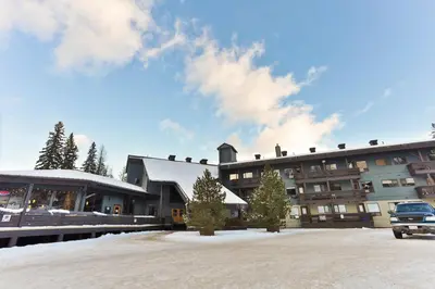 a large building with a car parked in front of it at Griz Inn by StayIn in Fernie