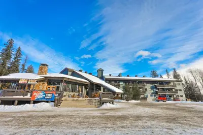 a resort building with snow on the ground at Griz Inn by StayIn in Fernie