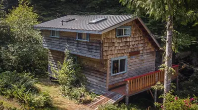 a log cabin with a solar roof on top of it at Woods End Landing in Bamfield