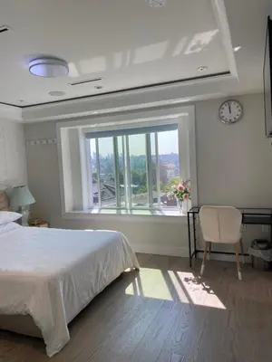 a bedroom with a bed and a large window at Six minutes to Rupert station in Vancouver