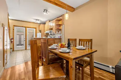 a kitchen and dining room with a wooden table and chairs at BANFF WOODS LODGE in Canmore
