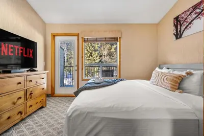 a bedroom with a large bed and a television at BANFF WOODS LODGE in Canmore