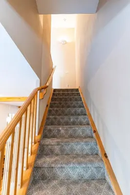 a staircase in a house with wooden railings at BANFF WOODS LODGE in Canmore