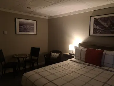 a hotel room with a bed and a table and chairs at The Cache Hotel and Lodgings in Golden