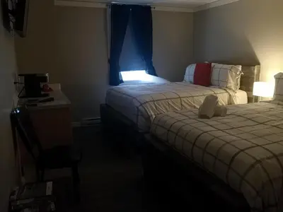 a hotel room with two beds and a window at The Cache Hotel and Lodgings in Golden