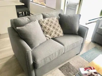 a gray couch with pillows in a living room at Hearthstone Lodge loft, Village centre, Private Hot tub, sleeps 6 in Whistler
