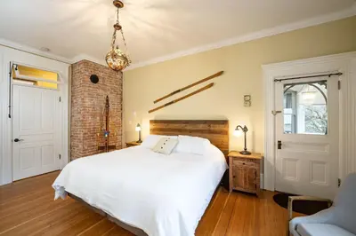 a bedroom with a white bed and a brick wall at The Copeland in Revelstoke