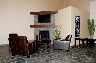 a living room with two chairs and a fireplace at Paradise Inn and Suites in Valleyview