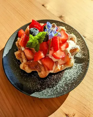 a plate of food with strawberries on a table at Maple Rise Guesthouse in Duncan
