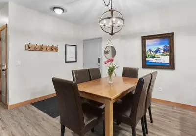 a dining room with a wooden table and chairs at Newly Renovated Grizzly Lodge, Spacious 3BR 2BA with open pool, hot tub in Canmore