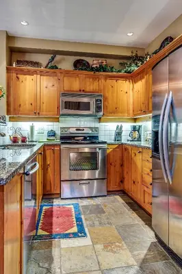 a kitchen with wooden cabinets and stainless steel appliances at Mountain Star 28 Hot Tub in Whistler