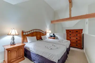 a bedroom with a bed and a dresser at Greystone Lodge 413 - Largest in Whistler