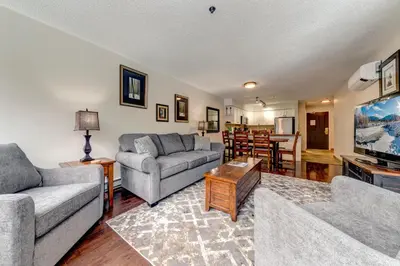 a living room with two couches and a flat screen tv at Greystone Lodge 333 Ski-in Out in Whistler