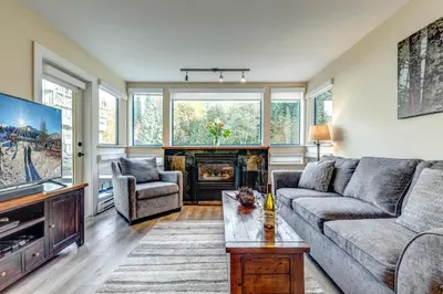 a living room with a couch and a tv at Greystone Lodge 226 Ski-in Out in Whistler