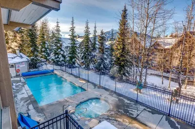 an indoor swimming pool in the snow on a balcony at Greystone Lodge 113 Ski-in Out in Whistler