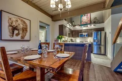 a kitchen and dining room with a wooden table and chairs at Greystone Lodge 310 Ski-in Out in Whistler