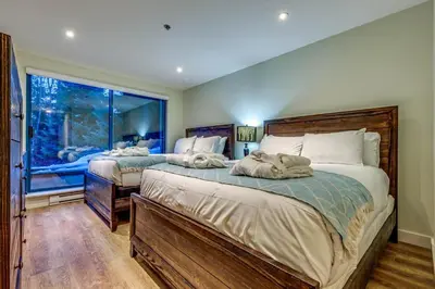 a bedroom with two beds and a window at Greystone Lodge 109 Ski-in Out in Whistler