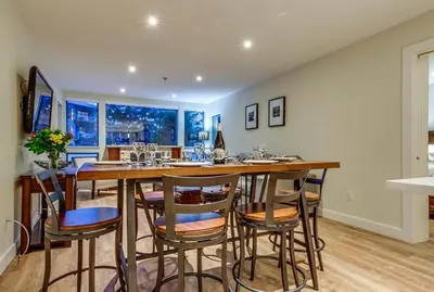 a kitchen with a large wooden table and chairs at Greystone Lodge 109 Ski-in Out in Whistler