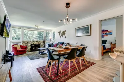 a dining room and living room with a table and chairs at Greystone Lodge 328 Ski-in Out in Whistler